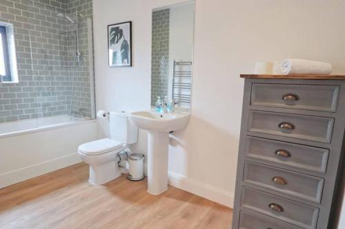 a bathroom with a white toilet and a sink at Contemporary 2 Bedroom Apartment with Parking in Bristol