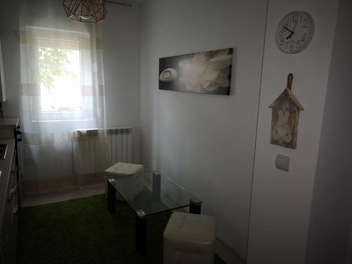 una habitación con una mesa de cristal y un reloj en la pared en Apartament Darius, en Târgu Ocna