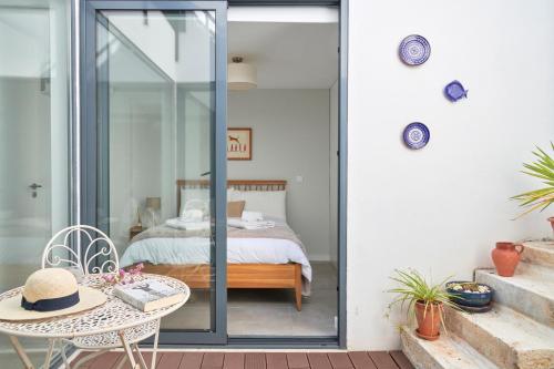 uma porta de vidro que leva a um quarto com uma cama em Charming house with terrace in Lisbon.WIFI. em Lisboa