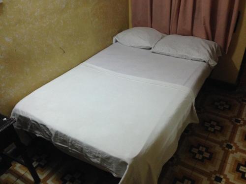 a bed with white sheets and pillows in a room at Hotel El Diamante CA in Barranquilla