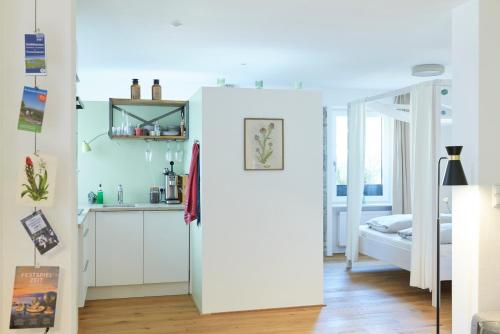 a kitchen with a white refrigerator in a room at Rotes Haus Bregenz Garten Wohnung in Bregenz
