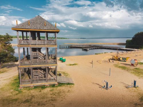 a lifeguard tower on a beach next to a body of water at Jarzębinowa - Dom do wynajęcia na Podlasiu in Łuka