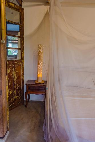 a room with a bed and a lamp on a table at Casa Grande Flats in Abraão