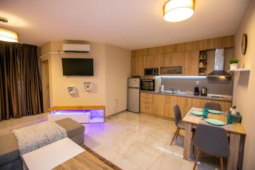 a living room with a table and a kitchen at Riva Apartment in Sandanski