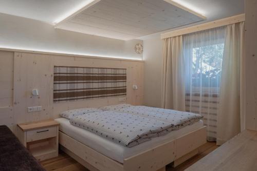 A bed or beds in a room at Ciasa Iachin Mountain Apartment