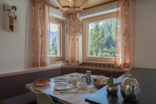 comedor con mesa y ventana en Ciasa Iachin Mountain Apartment en San Martino in Badia