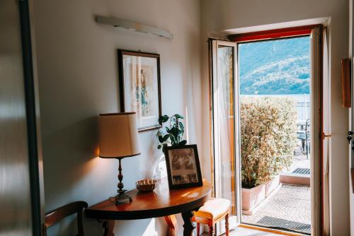 a room with a table and a door to a balcony at Hotel Ristorante La Quartina in Mergozzo
