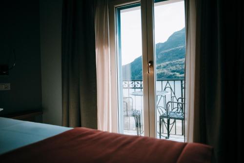 a bedroom with a window with a view of a balcony at Hotel Ristorante La Quartina in Mergozzo