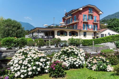 una casa grande con flores delante en Hotel Ristorante La Quartina, en Mergozzo