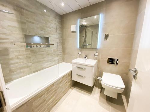 uma casa de banho com um WC, uma banheira e um lavatório. em Glasgow 2bd City Centre Apartment - Free Private Parking em Glasgow