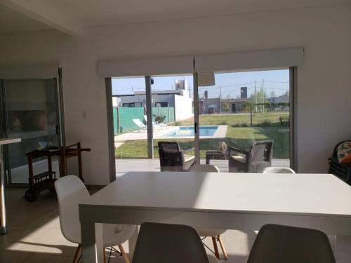 a dining room with a white table and chairs at DOLCE LUNA in Roldán