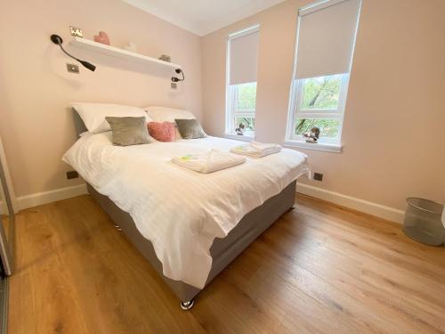 sypialnia z dużym łóżkiem z białą pościelą i poduszkami w obiekcie Glasgow 2bd City Centre Apartment - Free Private Parking w Glasgow