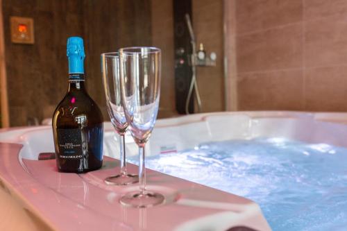 a bottle of wine and two champagne glasses in a tub at Waterfront Lodge in Dunapataj
