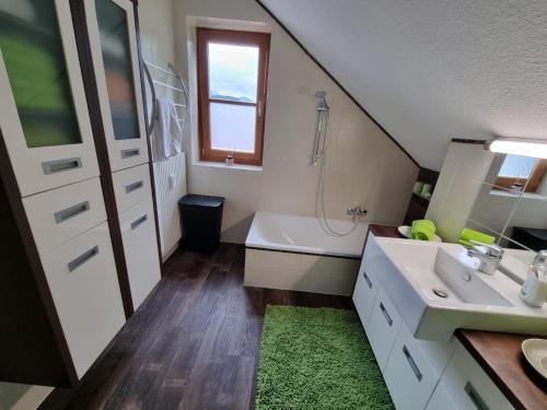 een badkamer met een wastafel en een bad bij Auszeit am Traunsee in Altmünster