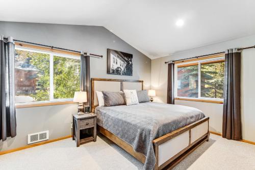 a bedroom with a bed and two windows at McCall Cottage Cabin in McCall