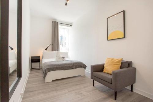 a bedroom with a bed and a chair at Modern & bright 1 bed for 4 close to city centre! in Edinburgh