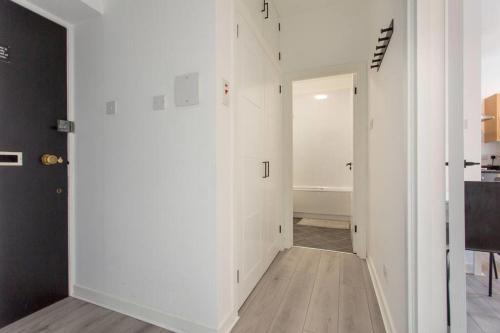a hallway with white walls and a white door at Modern & bright 1 bed for 4 close to city centre! in Edinburgh