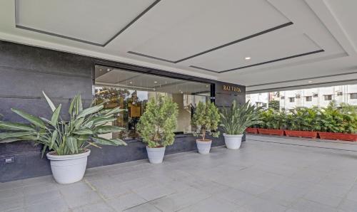 a row of potted plants in front of a store at Treebo Premium Raj Vista Global Village in Bengaluru