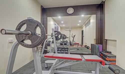a gym with a bench and a bunch of weights at Treebo Premium Raj Vista Global Village in Bengaluru