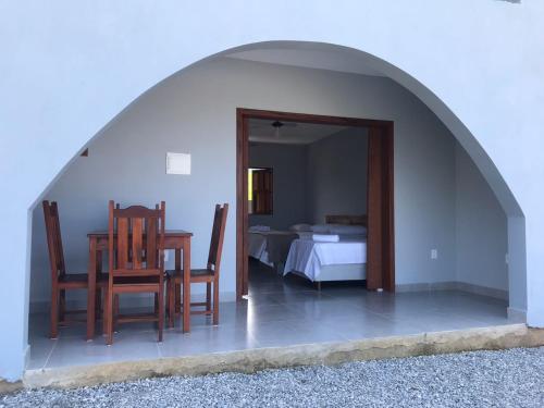 a room with a table and chairs and a bed at Recanto Filadélfia in Paraty