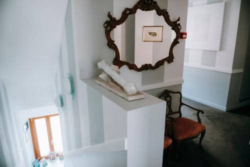 a mirror sitting on a wall in a room at Hotel Ristorante La Quartina in Mergozzo