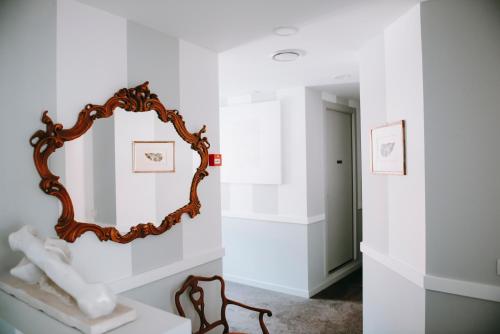 a mirror on a white wall in a room at Hotel Ristorante La Quartina in Mergozzo