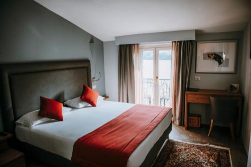 a hotel room with a bed and a window at Hotel Ristorante La Quartina in Mergozzo