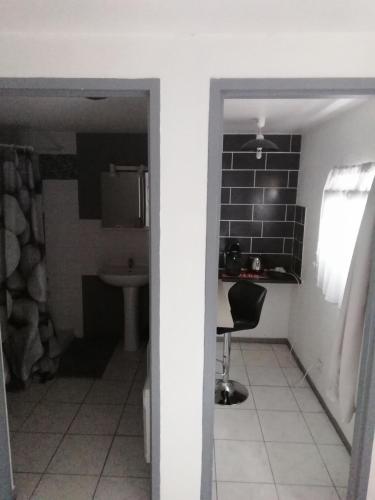 un couloir avec une cuisine et une chaise dans la chambre dans l'établissement SAMANKE lOUNGE, à Floirac