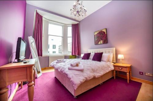 a bedroom with a bed and a desk and a tv at Renfield Apartment, Bright and Spacious Home in Glasgow