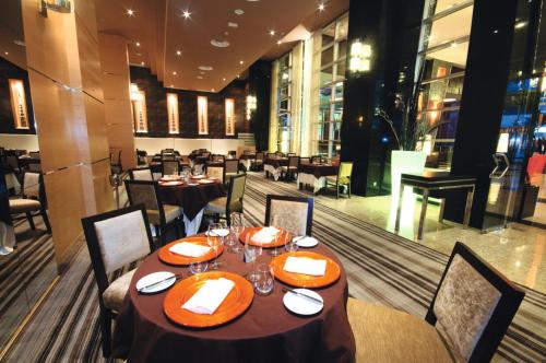 a dining room with tables and chairs in a restaurant at Riu Plaza Panamá in Panama City