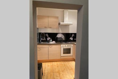 a kitchen with wooden cabinets and a wooden floor at Die kleine Post in Schleiden