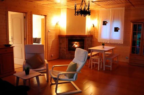 salon z dwoma stołami i kominkiem w obiekcie MI CASA DE MADERA w mieście Paúl