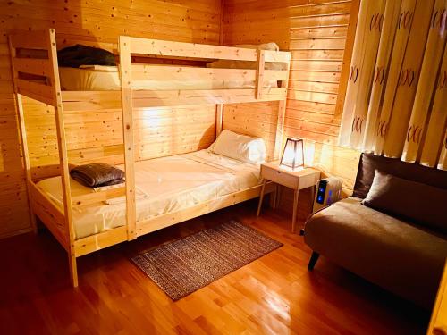 sypialnia z 2 łóżkami piętrowymi w kabinie w obiekcie MI CASA DE MADERA w mieście Paúl