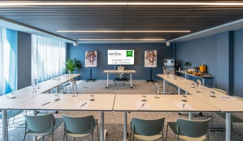 a conference room with tables and chairs and a screen at Ibis Styles Madrid City Las Ventas in Madrid