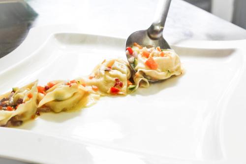 a plate of food with a spoon and pasta at Hotel Ristorante La Quartina in Mergozzo
