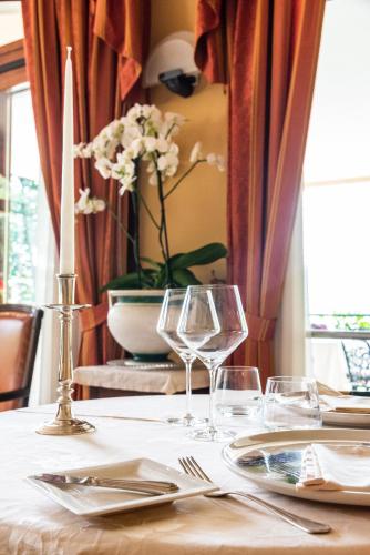 a table with two wine glasses and a candle on it at Hotel Ristorante La Quartina in Mergozzo