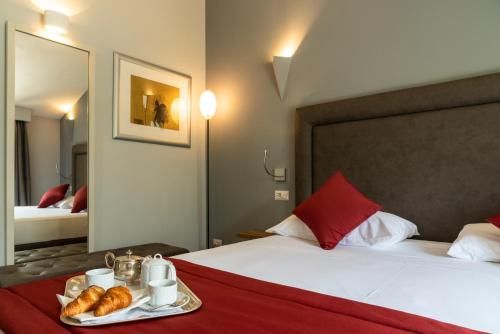 a hotel room with a bed with a tray of croissants at Hotel Ristorante La Quartina in Mergozzo