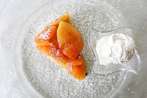 a glass plate with a piece of fruit and whipped cream at Hotel Ristorante La Quartina in Mergozzo