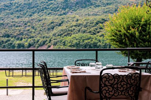a table with chairs and a view of the water at Hotel Ristorante La Quartina in Mergozzo