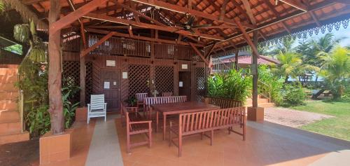 a wooden pavilion with a table and chairs on a patio at Bayu Beach Penarek in Penarek