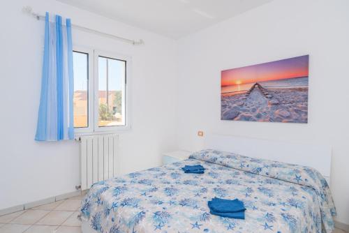 a white bedroom with a bed and a window at Appartamento Murena 1 in La Maddalena