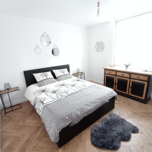 - une chambre avec un lit noir et blanc et un tapis dans l'établissement Appart Coeur de Rouen - Majestic, à Rouen