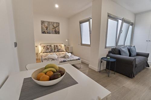 a living room with a bowl of fruit on a table at Malibú Canteras Studio 8 - Playa, WiFi, SmartTV, AC in Las Palmas de Gran Canaria