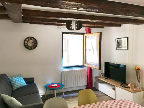 Una sala de estar con un sofá y un televisor. en Gîtes La Petite Venise Colmar, en Colmar