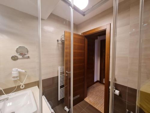 a bathroom with a glass shower door and a sink at Apartment B513 in Jahorina