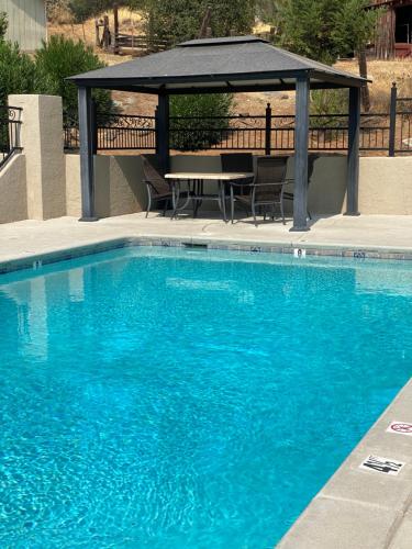 a swimming pool with a table and a gazebo at Country Inn Sonora in Sonora
