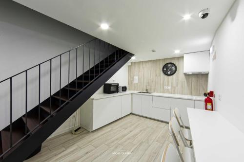 una cocina con una escalera que conduce a una sala de estar. en Host'olaria, en Lamego