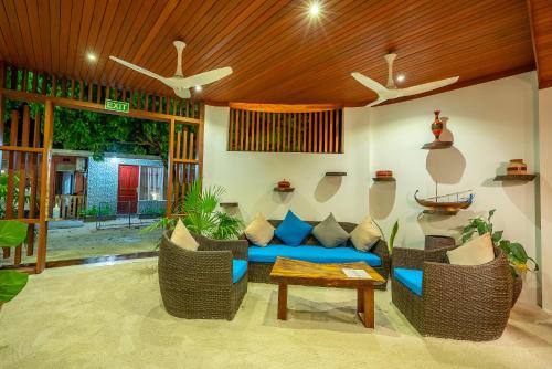 a living room with a blue couch and chairs at Ithaa Dhigurah Maldives in Dhigurah