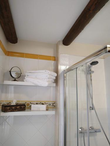 a bathroom with a shower and some white towels at La Simona Casa Rural in Perales del Puerto