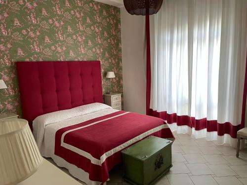 een slaapkamer met een bed met een rood hoofdeinde bij Centro Storico, Piazza Carmine: La Casa di Angela in Reggio di Calabria